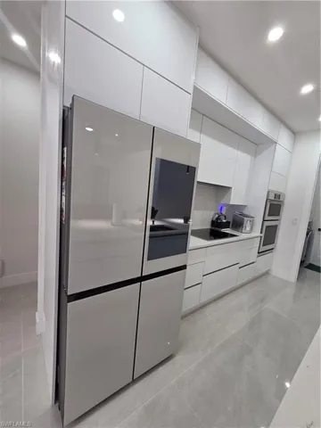 Kitchen featuring recessed lighting, light countertops, white cabinets, modern cabinets, and stainless steel appliances