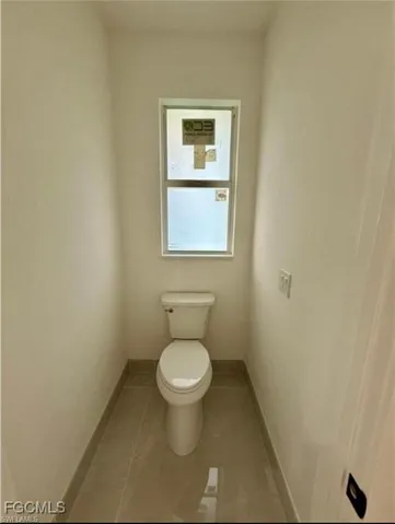 Bathroom with toilet and light tile patterned floors
