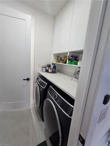 Laundry area with cabinet space and washer and clothes dryer