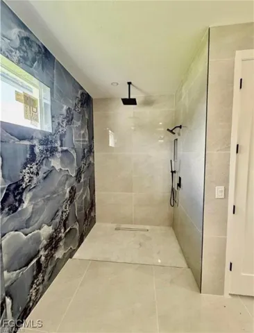 Bathroom with a walk in shower and tile walls