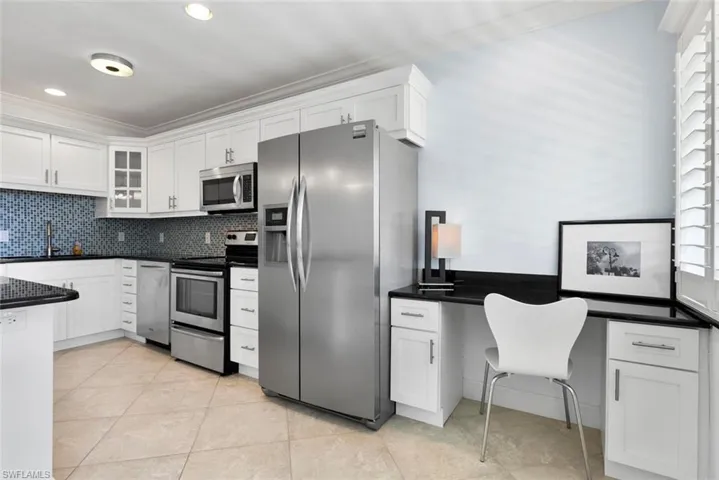 Kitchen featuring appliances with stainless steel finishes, sink, and white cabinets