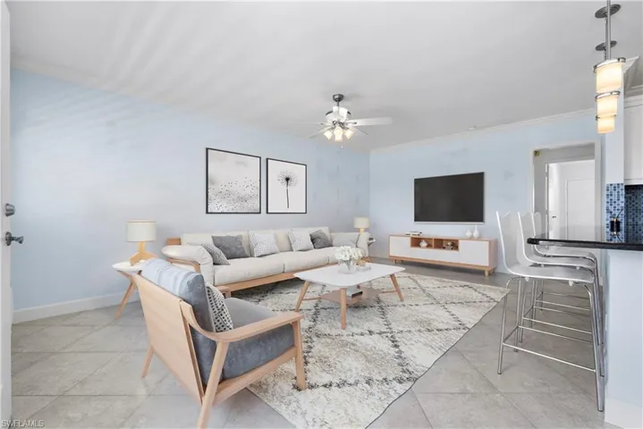 Virtually staged living room featuring ceiling fan and ornamental molding