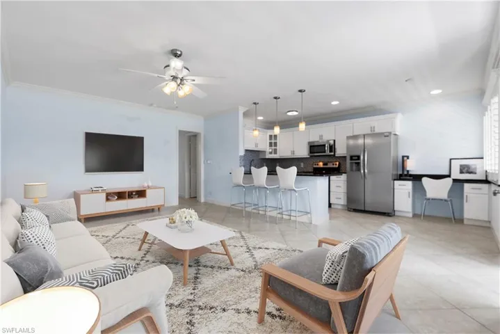 Virtually staged living room featuring ceiling fan and crown molding