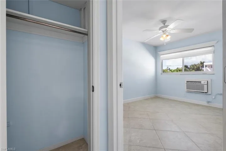 Closet featuring an AC wall unit in bedroom