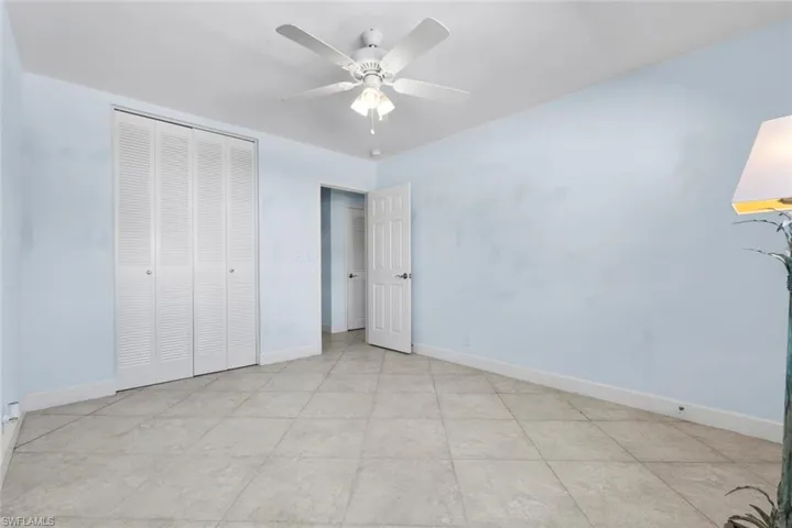 Unfurnished bedroom with ceiling fan and a closet