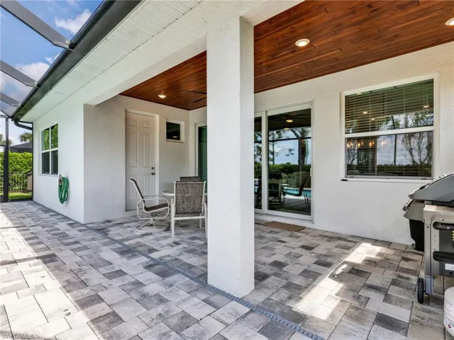 Covered patio with a wood-finish ceiling, recessed lighting, and a textured white exterior