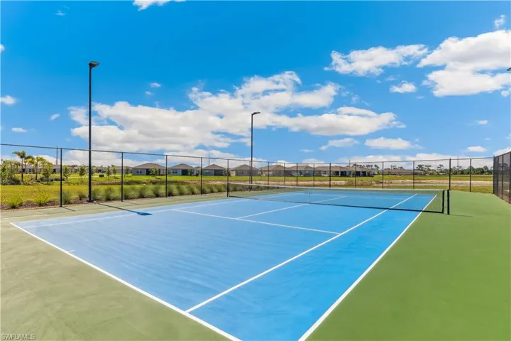 View of tennis court featuring community basketball court and a residential view