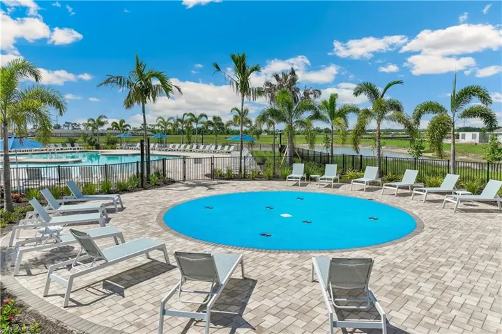 Community pool with a patio area and a water view