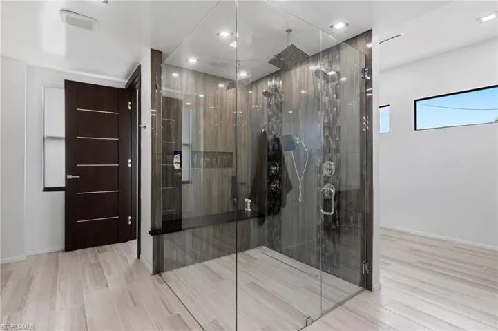 Bathroom featuring wood-type flooring and a shower with door