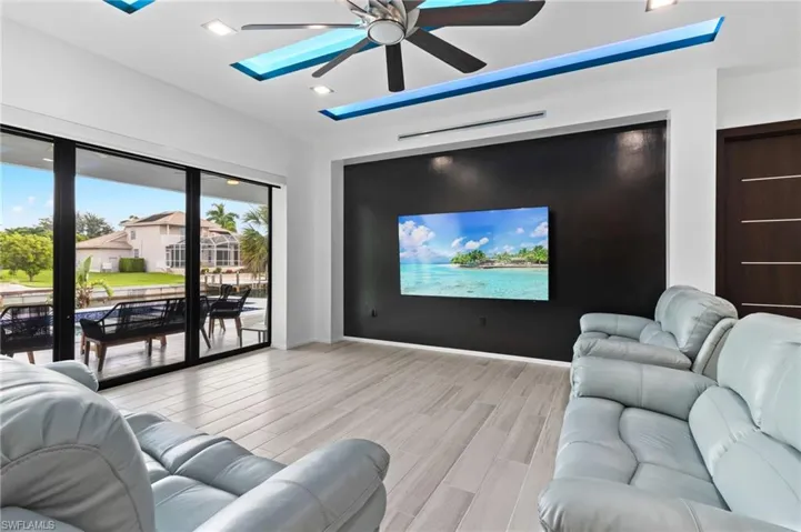 Home theater room featuring light hardwood / wood-style floors and ceiling fan