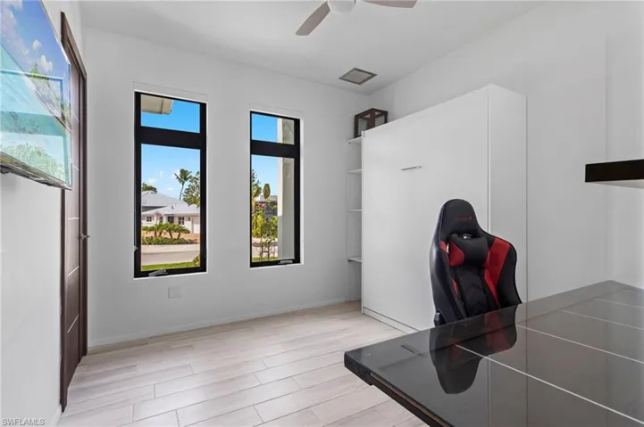 Office space with light wood-type flooring and ceiling fan
