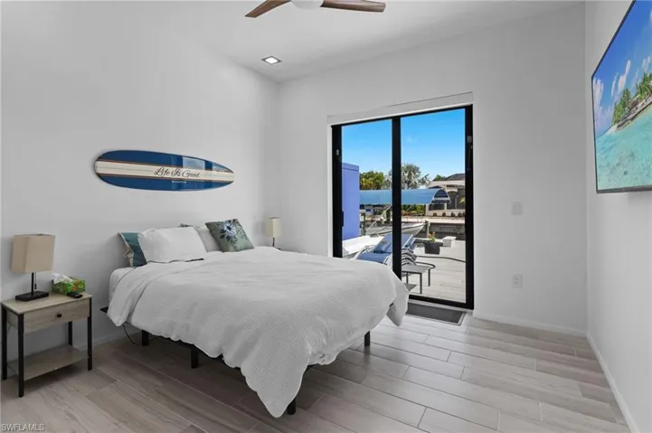 Bedroom with light hardwood / wood-style floors, ceiling fan, and access to outside