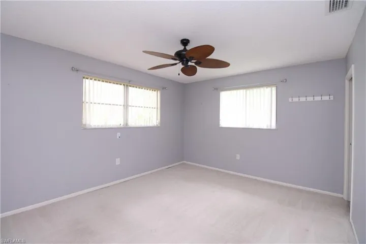 Unfurnished room with carpet, ceiling fan, and a healthy amount of sunlight