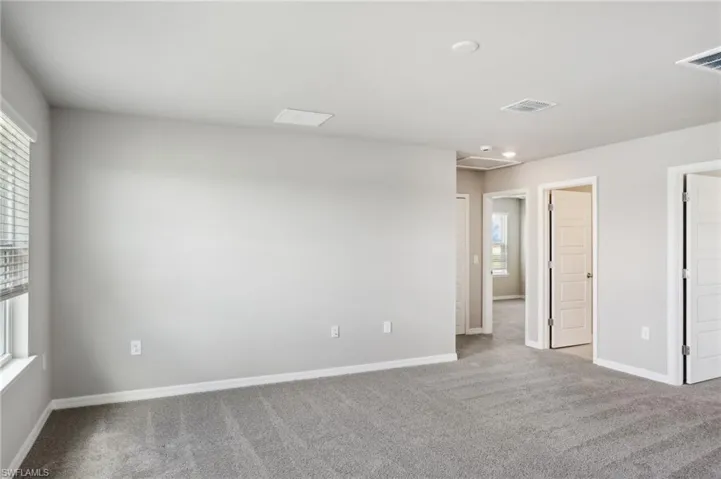 Carpeted empty room featuring baseboards