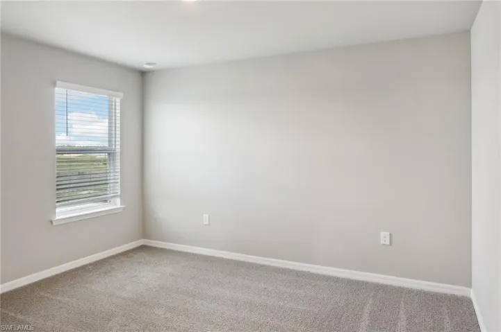 Carpeted empty room featuring baseboards