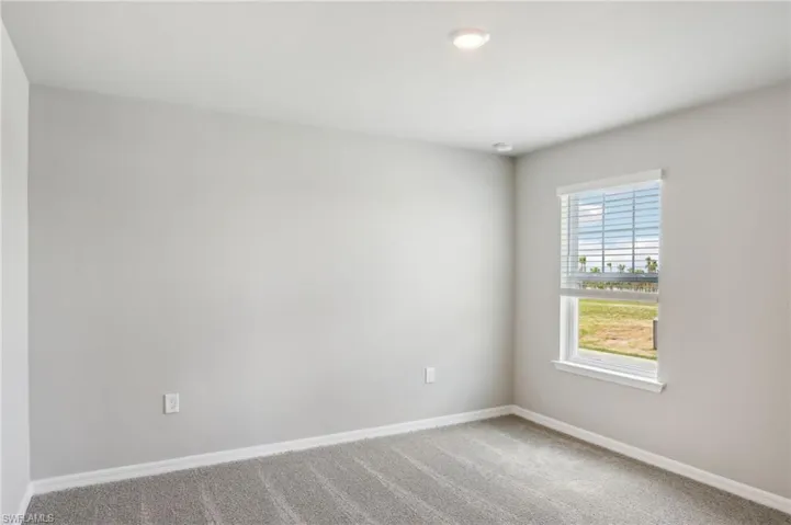 Carpeted spare room with baseboards