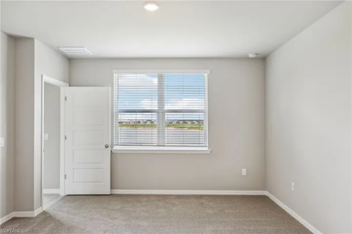 Carpeted spare room featuring baseboards