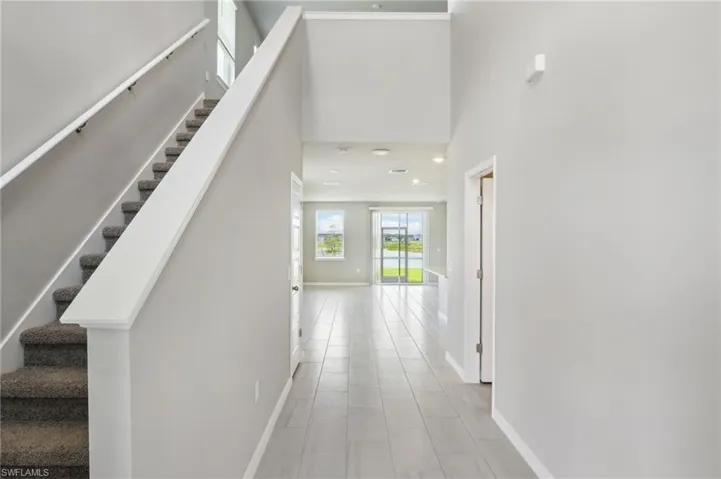 Stairway featuring baseboards and a high ceiling