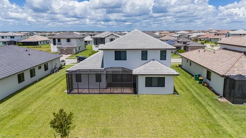 Back of property with a lanai and a yard