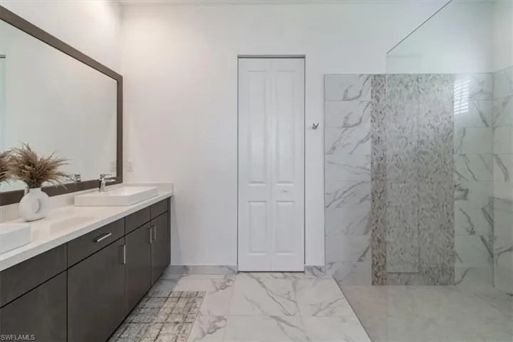 Bathroom featuring doublevanity,oversized tiled shower