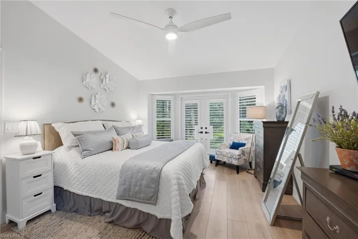 Spacious primary suite with vaulted ceilings and french doors to the lanai