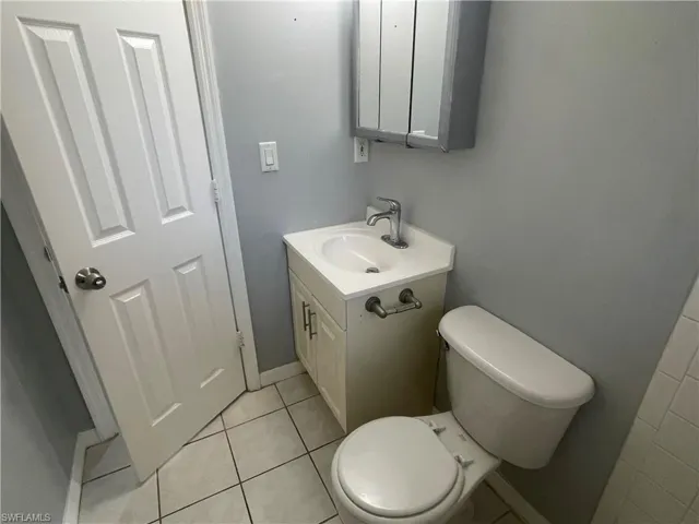 Half bath with vanity and light tile patterned floors