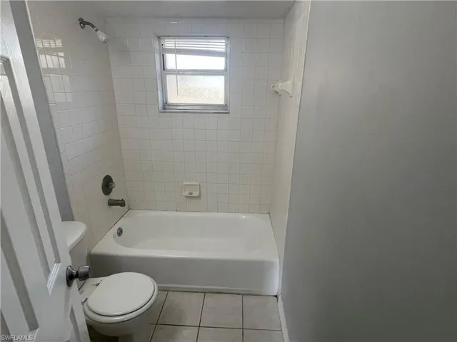 Full bathroom with shower / washtub combination and tile patterned flooring
