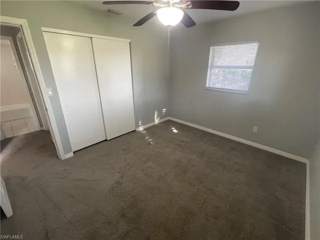 Unfurnished bedroom with carpet floors, ceiling fan, and a closet