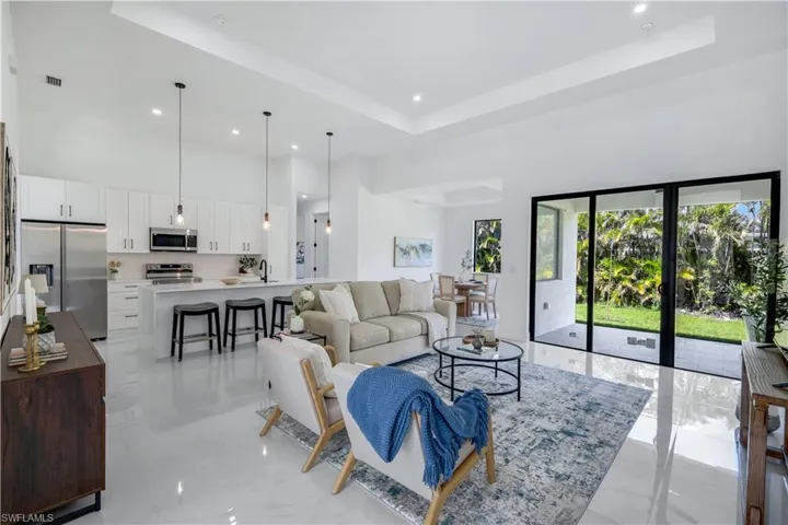 Living area with a towering ceiling, a raised ceiling, and recessed lighting