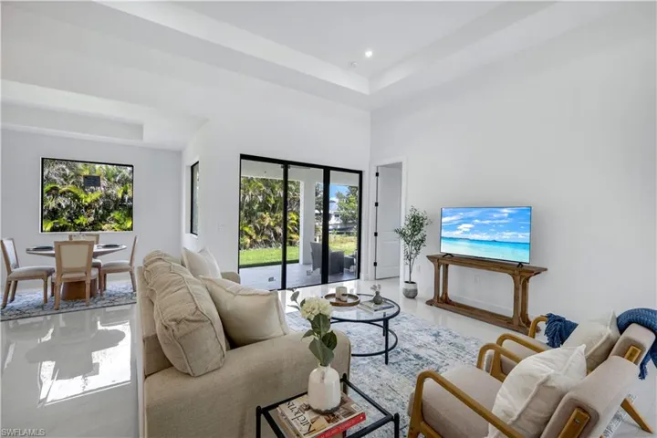 Living area with healthy amount of natural light, a high ceiling, and recessed lighting