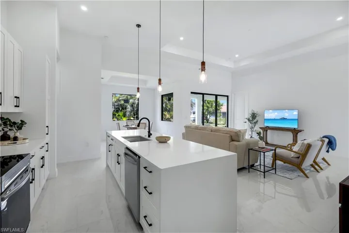 Kitchen with a sink, stainless steel dishwasher, electric range, recessed lighting, and light countertops