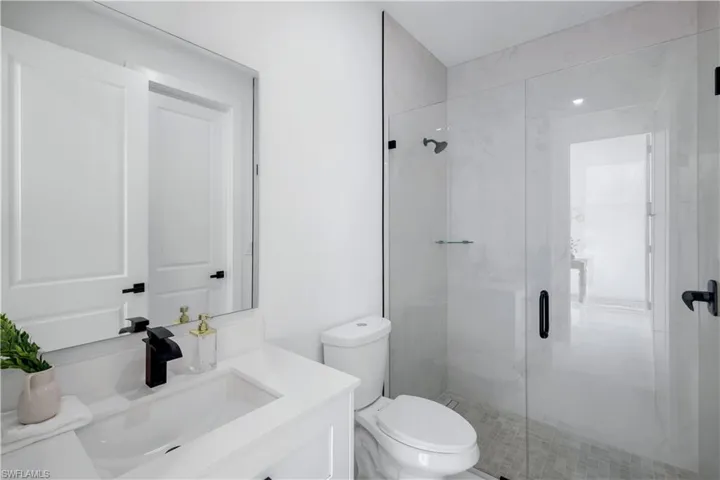 Bathroom with a shower stall, toilet, and vanity