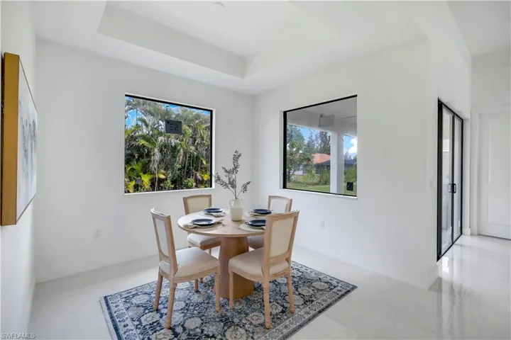 Dining area featuring a tray ceiling and baseboards