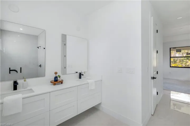 Bathroom featuring a stall shower, double vanity, baseboards, recessed lighting, and marble finish floors