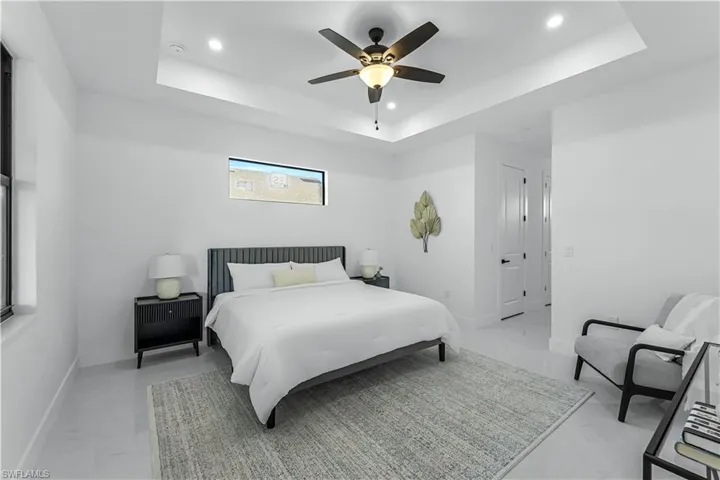 Bedroom with recessed lighting, baseboards, a tray ceiling, and ceiling fan