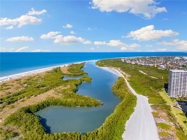 Birds eye view of property with a view of the beach and a water view