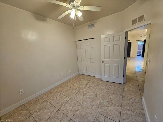 Unfurnished bedroom with a ceiling fan and a closet