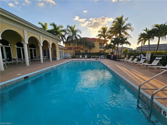 Pool at dusk with a patio and a community pool