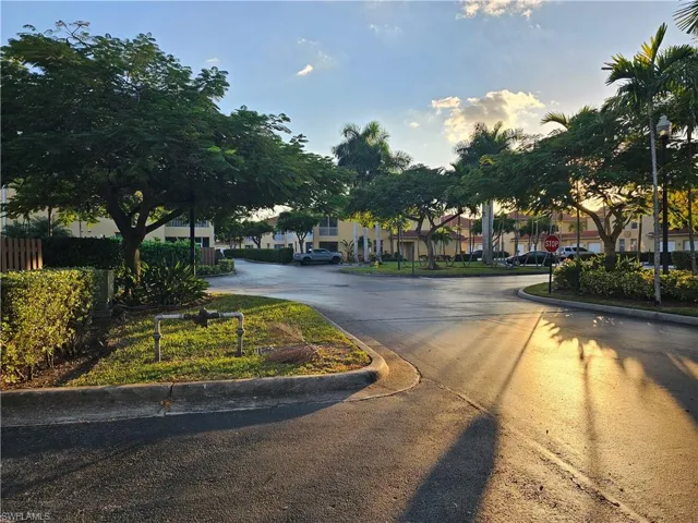 View of asphalt street featuring traffic signs and curbs