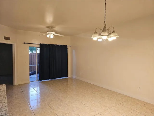 Empty room with ceiling fan and a chandelier