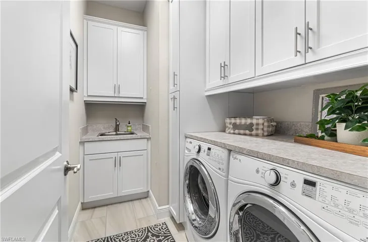 LAUNDRY ROOM WITH A WASHER/DRYER, PLENTY OF WHITE CABINETS WITH SOFT-CLOSE DRAWERS, COUNTERTOP FOR FOLDING OF CLOTHES & A SINK! THIS HOME TRULY HAS IT ALL.