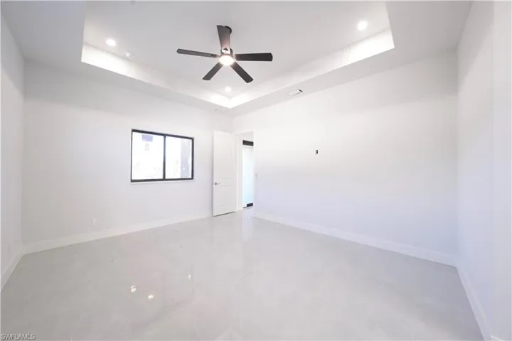 Spare room with recessed lighting, a raised ceiling, and ceiling fan