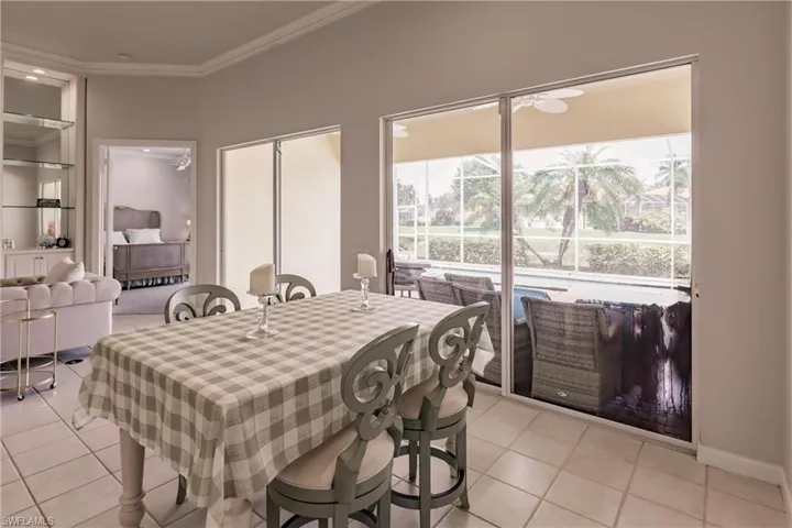 Dining room with light tile patterned floors and crown molding