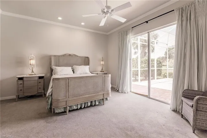 Bedroom featuring multiple windows, light colored carpet, crown molding, and access to outside