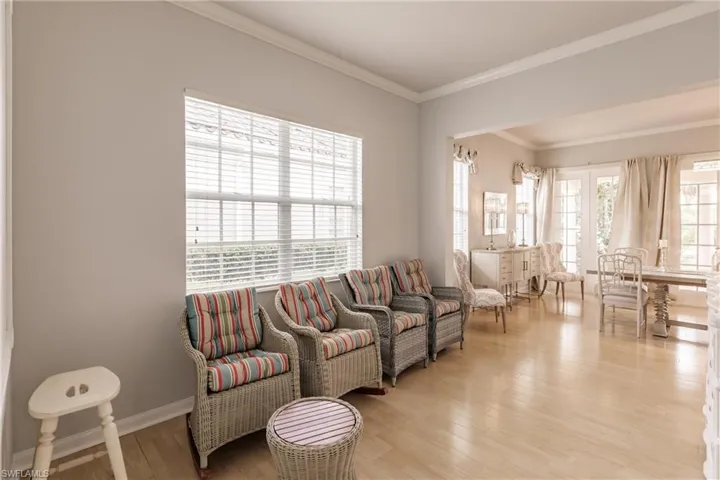Living room with crown molding and light hardwood / wood-style flooring