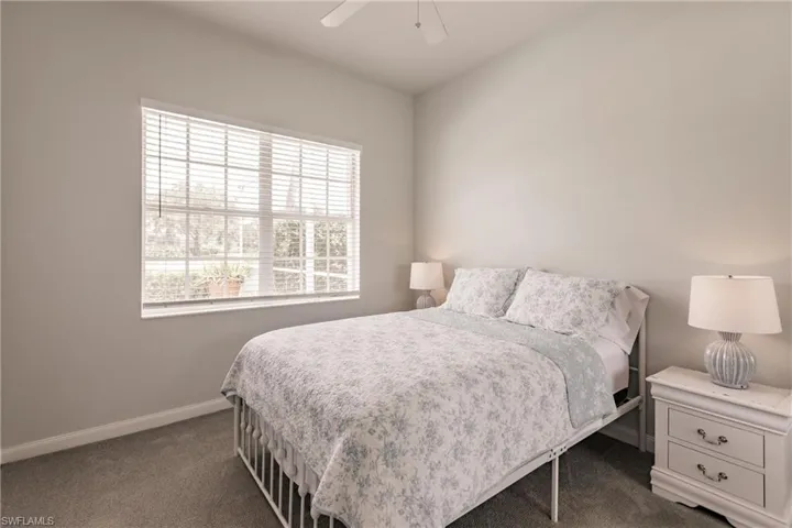 Carpeted bedroom featuring ceiling fan