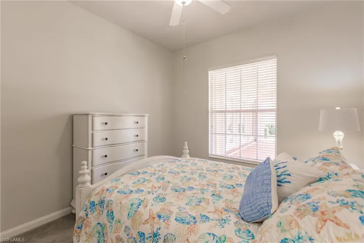 Carpeted bedroom featuring ceiling fan