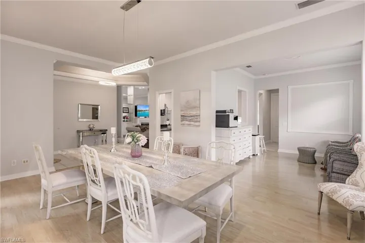Dining space featuring crown molding and light wood-type flooring