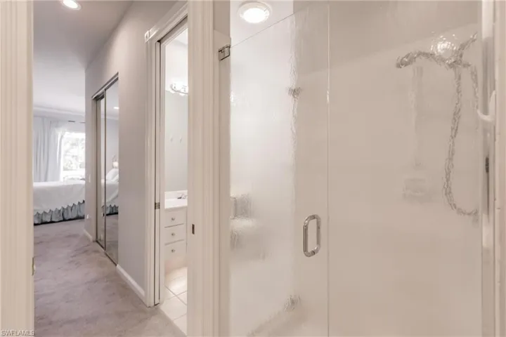 Bathroom with a shower with door, vanity, and tile patterned flooring