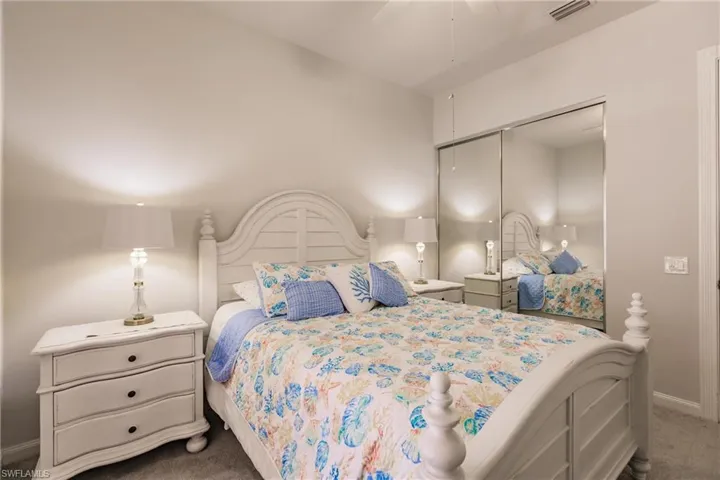 Carpeted bedroom with ceiling fan and a closet